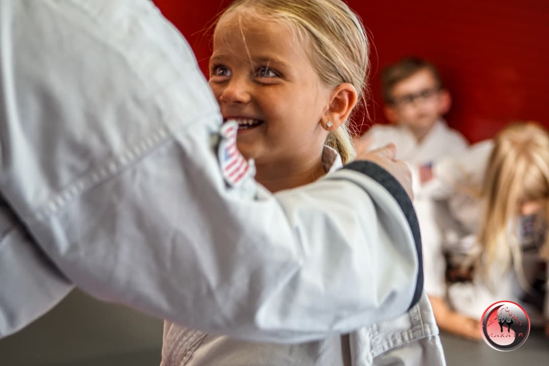 Coach holding focus mitts for a young student at East Coast Karate